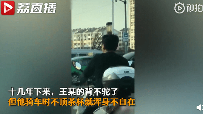 男子頭頂茶杯騎車糾正駝背 究竟是怎么一回事