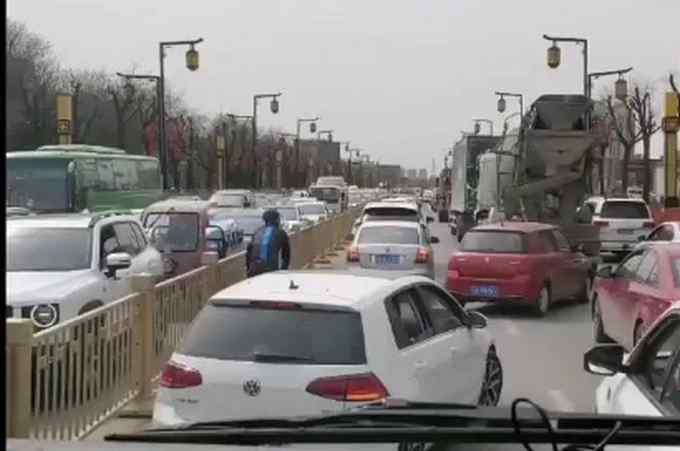 西安一男子騎著單車穿行車流 為消防開道 疏通距離大概一公里